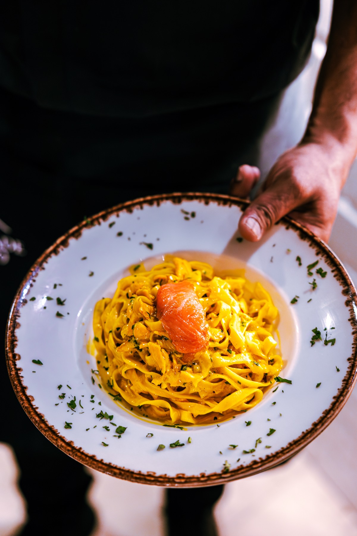 Prato de tagliatelle com salmão, servido em louça artesanal